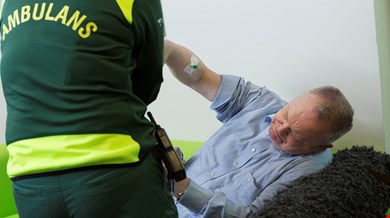 Ambulanssjuksköterska undersöker äldre man