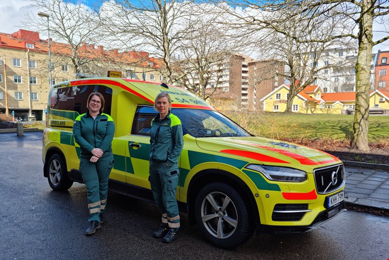 Ambulanssjuksköterskorna Ida och Karin framför en ambulans